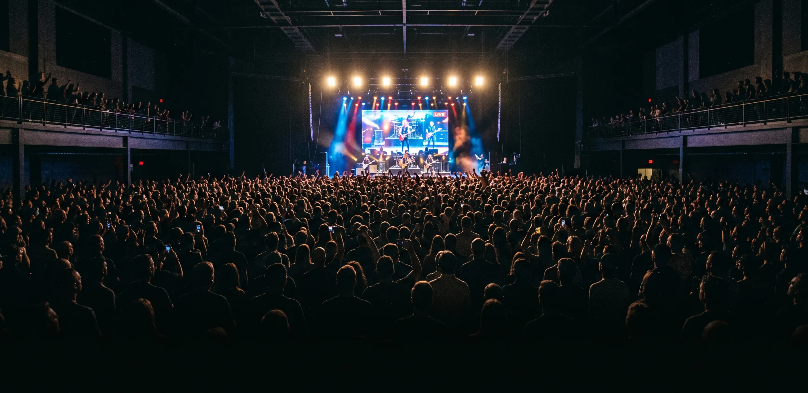 Concert live à guichets fermés, foule debout devant la scène